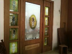 the door with green nd yellow glass work enhancing the elegance of door 