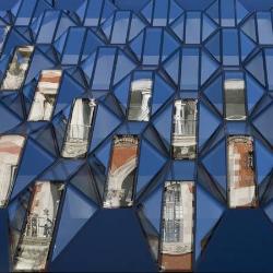 The glass exterior design that shows the reflection of surrounding buildings!