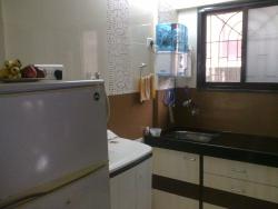 A corner with a washing machine and a Sink with storage around the place