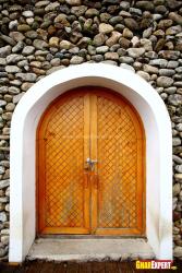 pebbled stone cladding for exterior main door wall  of upper portion of door wall