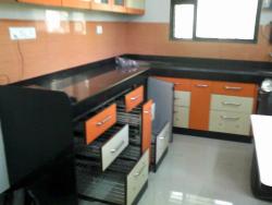 Kitchen cupboards done with twin colored laminates and using modular accessories  of wooden cupboards