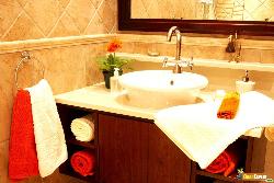 Beautiful sink in a bathroom with towel on it and a flower Interior Design Photos